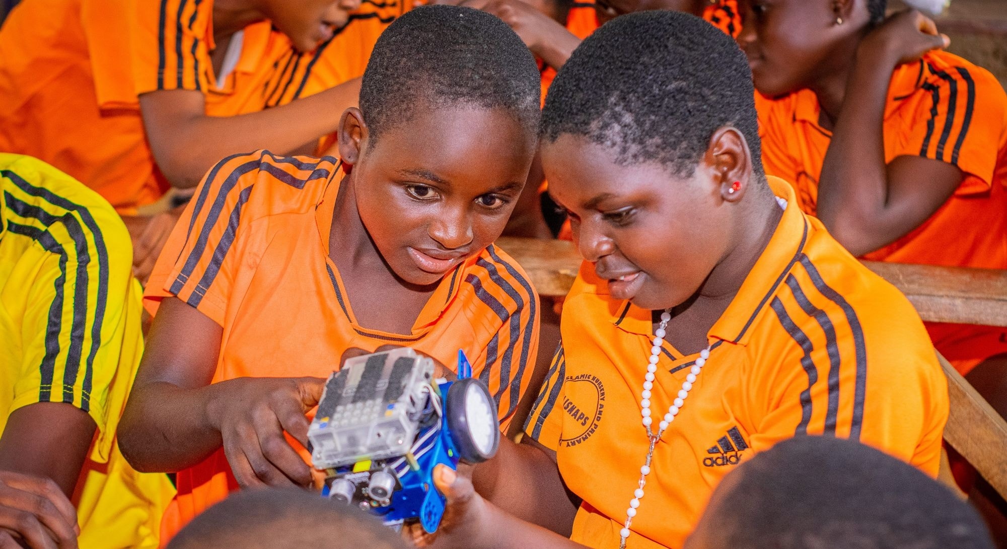 Two pupils examining a small robot car they are working on